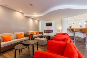 - un salon avec des canapés et des oreillers orange dans l'établissement Luna Fatima Hotel, à Fátima