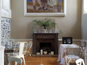 Una sala de estar con chimenea y una mesa y sillas. en Hosteria de Arnuero, en Arnuero
