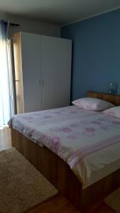 a bedroom with a large bed with pink flowers on it at Guesthouse Matušan's place in Rab