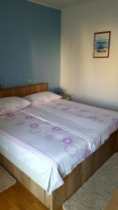 a bedroom with a large bed with pink sheets at Guesthouse Matušan's place in Rab