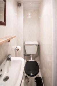 黑潭的住宿－MyRoomz Hollingdales Hotel，白色的浴室设有黑色的卫生间和浴缸。