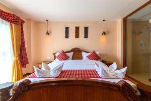 1 dormitorio con 1 cama grande con almohadas rojas y blancas en Nivas Boutique Home en Katmandú