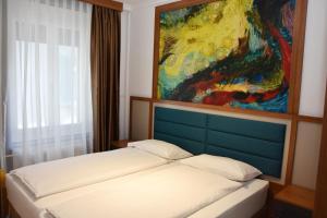1 dormitorio con 1 cama con una pintura en la pared en Comfort Apartments by Livingdowntown, en Zúrich