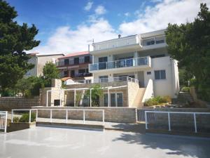 duży biały budynek z patio przed nim w obiekcie Beachfront Apartments - Villa Vita w mieście Stara Novalja