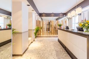 una hall con ufficio, bancone della reception e piante di Sure Hotel by Best Western Paris Gare du Nord a Parigi