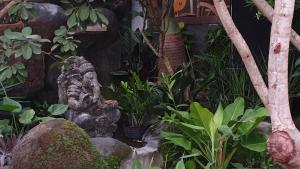 a garden with a statue and some plants at Clover Bali in Jimbaran +18 photos