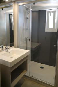 ein Badezimmer mit einem Waschbecken und einer Dusche mit einer Glastür in der Unterkunft VVF Corrèze Pays d'Eygurande in Eygurande