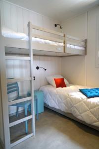 a bedroom with two bunk beds and a desk at VVF Corrèze Pays d'Eygurande in Eygurande