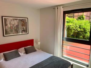 um quarto com uma cama e uma grande janela em Les Appartements du Renard em Estrasburgo