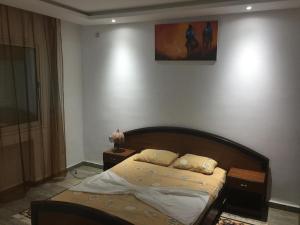 1 dormitorio con 1 cama y una pintura en la pared en Penthouse avec vue imprenable sur mer, en Chott Meriem