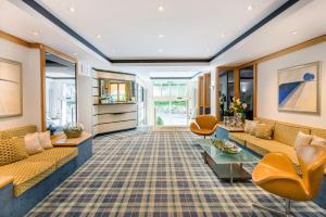 a living room with couches and chairs at Hotel Am Nockherberg in Munich