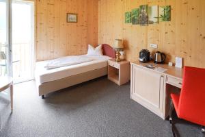 リエンツにあるFalken Horst Lienzのベッドルーム1室(ベッド1台、デスク、赤い椅子付)