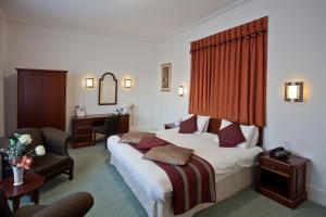 a hotel room with two beds and a desk at North Stafford Hotel in Stoke on Trent