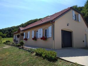 una casa blanca con garaje y patio en chambre d hôtes à la campagne en Tilleux