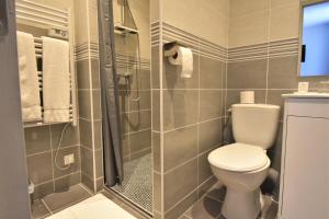 a bathroom with a toilet and a shower at Hôtel des 2 Gares in Auxerre