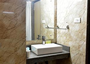 y baño con lavabo blanco y espejo. en Hotel City Inn, en Varanasi