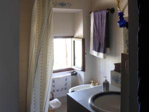 a bathroom with a tub and a sink and a window at Casa Elena sul mare a Torre di Palme in Marina Palmense