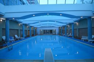 a large swimming pool with blue lighting in a building at Hotel Vlora International in Vlorë