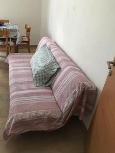 ein Bett mit einer rosa Decke und 2 Kissen in der Unterkunft Casa vacanze P&G. Colline, mare, relax in La Spezia