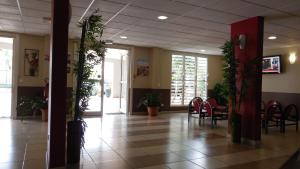 eine Lobby mit einem Tisch, Stühlen und Pflanzen in der Unterkunft Centre International de Sejour in Fort-de-France