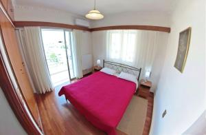 a bedroom with a bed with a red blanket at Casa di Sole in Nikiana