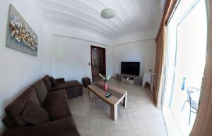 a living room with a couch and a tv at Casa di Sole in Nikiana