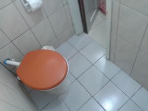 La salle de bains est pourvue de toilettes avec un siège orange. dans l'établissement Pousada São Francisco de Paula, à Ouro Preto