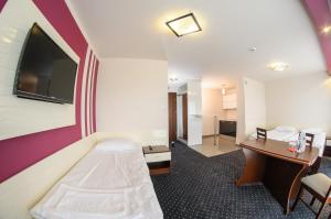 a hotel room with a television and a bed at Hotel Imperium in Pionki
