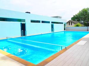 a swimming pool in front of a house at Blue Orchids Hotel in Hat Yai