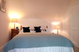 a bedroom with a large bed with black pillows at Moorings View in Instow