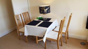 a table with two chairs and a lamp on it at Moorings View in Instow