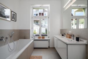 a white bathroom with a tub and a sink and a bath tub at Hotel Rosenhof in Kühlungsborn +232 photos