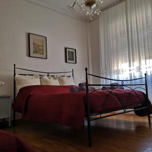 um quarto com uma cama com lençóis vermelhos e uma janela em Interno3 em Ancona