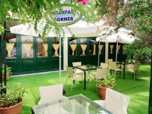 a restaurant with white chairs and tables and umbrellas at Homely Studios in Chios