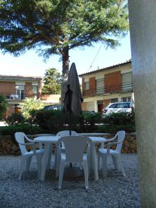 a white table and chairs with an umbrella at Appartamento il Geranio in Quercianella