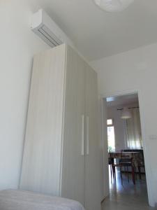 a white cabinet in a bedroom with a dining room at Appartamento il Geranio in Quercianella