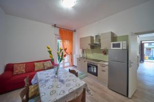 a kitchen and living room with a table and a red couch at Casa della nonna in Abbadia Lariana