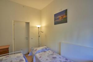 a bedroom with two beds and a picture on the wall at Casa della nonna in Abbadia Lariana