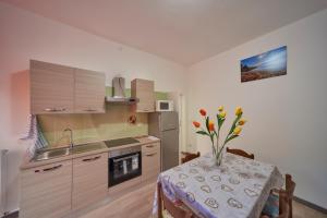 a kitchen with a table with a vase of flowers at Casa della nonna in Abbadia Lariana