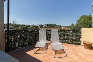 twee stoelen bovenop een patio bij Hill's view terrace apartment in Florence