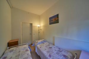 a bedroom with two beds and a picture on the wall at Casa della nonna in Abbadia Lariana
