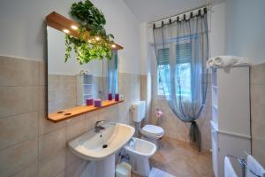 a bathroom with a sink and a toilet and a mirror at Casa della nonna in Abbadia Lariana