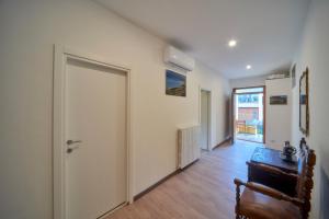 a hallway with a door and a table and a chair at Casa della nonna in Abbadia Lariana