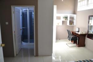 a bathroom with a desk and a glass shower at Triple Palms Bed and Breakfast in Gaborone