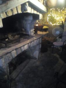 a stone fireplace in a room with chairs and a table at Apartman i Sobe Čule Cres in Cres
