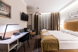a hotel room with two beds and a television at Hotel Perfect in Krakow