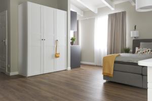 a bedroom with a bed and a white cabinet at Villa am Park in Binz