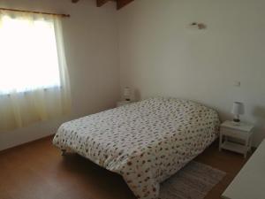 ein kleines Schlafzimmer mit einem Bett und einem Fenster in der Unterkunft Casa Pompona 3 in Rogil