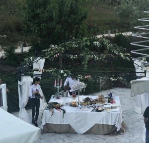 a table with food and a woman standing next to it at La Collina dei Colori in Vasto