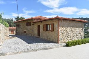 una pequeña casa de piedra con una pared de piedra en Quinta do Perguntouro, en Barrosas